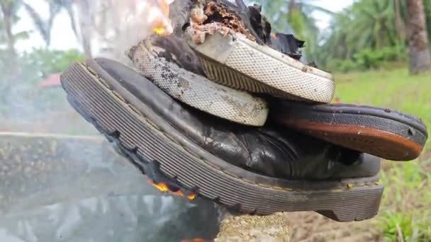 旧鞋子被火堆扔在圆柱形混凝土井边 302614172 — 图库视频影像