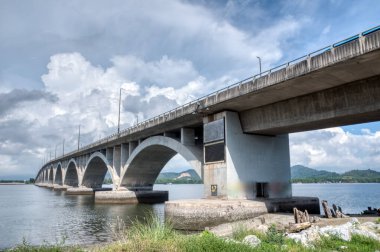 Beton köprü etrafında gündüz vakti olay yeri aktivitesi. 