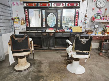 Perak, Malezya. Mart 30,2024: Kg Koh Eski kasaba sokağındaki Çin berber dükkanında sakin bir retro-yaşlanma sahnesi.