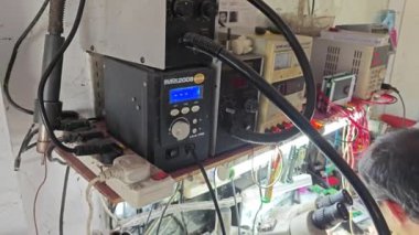 Perak, Malezya. 2 Nisan 2024: Mobil teknisyen atölyesinde Mas Kulaklık Tamir ve Servis Dükkanı 'ndaki müşteri cep telefonunu tamir ediyor ve onarıyor, Kg Koh.