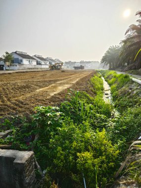 Perak, Malezya. 6 Nisan 2024: Taman Desa Permai Kg Koh yorumlama sahasındaki yeni inşaat sahasında kedi kazıcı toprağı büyük kamyonun arkasına taşıyor.