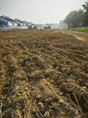 Perak, Malezya. 6 Nisan 2024: Taman Desa Permai Kg Koh yorumlama sahasındaki yeni inşaat sahasında kedi kazıcı toprağı büyük kamyonun arkasına taşıyor.