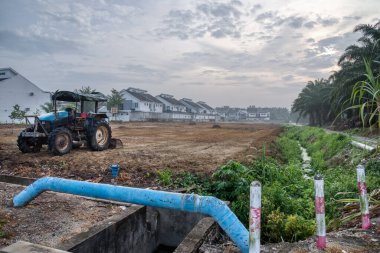 İnşaat alanındaki araziyi temizledikten sonra traktör tek başına bırakılmış..