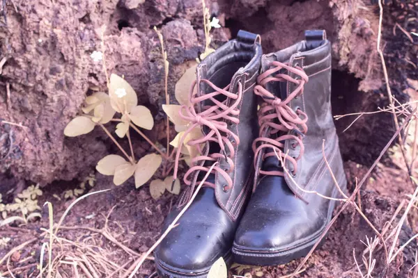 infrared image of old thrown away leather boot found in the wild meadow.