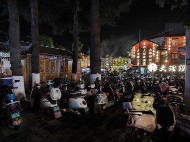 Dali, Çin, 20 Nisan 2024: Çin 'in Yunnan ilindeki Dali antik kentinde yiyecek ve ticaret malları arayan turistlerin yoğun caddelerin renkli gece manzarası