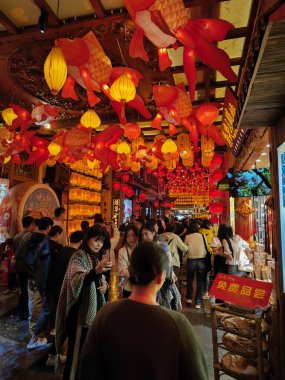 Dali, Çin, 20 Nisan 2024: Çin 'in Yunnan ilindeki Dali antik kentinde yiyecek ve ticaret malları arayan turistlerin yoğun caddelerin renkli gece manzarası