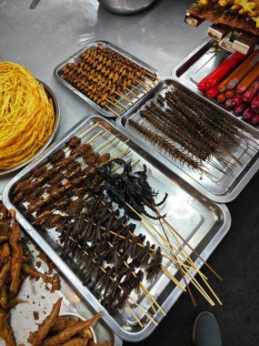 Çin, Kunming sokaklarında egzotik kızarmış böceklerin atıştırma sahnesi..