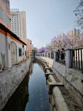 Yunnan, Çin. 26 Nisan 2024: Kunming kentsel iş caddesinde yürüyen insanların çevre şehri sahnesi.