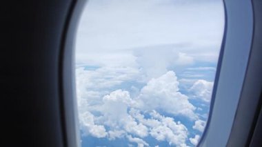 Uçak penceresinden gündüz gökyüzünün ve karanın çevresine bakın.