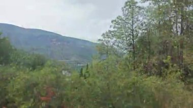 hareketli otobüs camından dağlık kırsal araziye bakıyor..