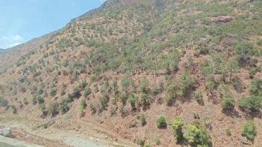 hareketli otobüs camından dağlık kırsal araziye bakıyor..