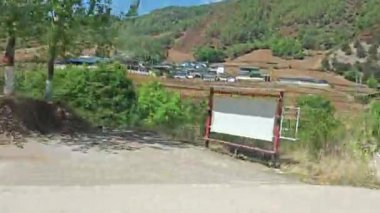 hareketli otobüs camından dağlık kırsal araziye bakıyor..