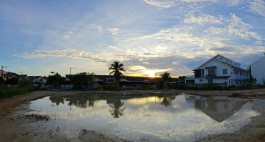 Yerleşim yerinin yakınındaki durgun çamurlu yağmur suyu havuzu boş görünüyor.. 