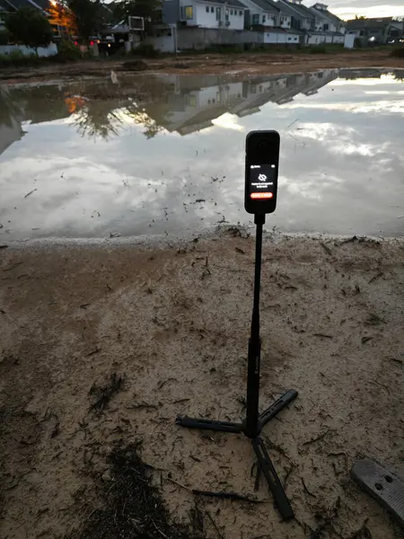 stock image Perak,Malaysia. June 10,2024: Scene of capturing footage using Insta360 device at the pool of water during the dawn hour at Taman Permai Vacant plot of land.