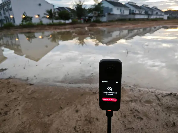 stock image Perak,Malaysia. June 10,2024: Scene of capturing footage using Insta360 device at the pool of water during the dawn hour at Taman Permai Vacant plot of land.