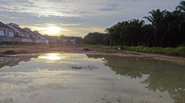 Yerleşim bölgesindeki durgun yağmur suyu havuzu üzerinde yansıtıcı sahne. 