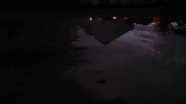 Yerleşim bölgesindeki durgun yağmur suyu havuzu üzerinde yansıtıcı sahne. 