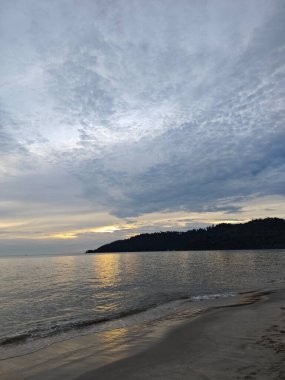 Kumsalda dinlenirken ve mavi gökyüzüne bakarken. 