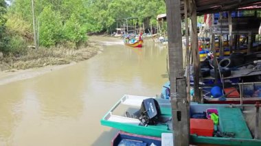 Perak, Malezya. 31 Temmuz 2024: Kg Pasir Panjang 'da teknelerin demirlediği nehir kıyısı boyunca yelken açan balıkçı teknesi sahnesi.  