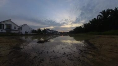 Boş arazinin yakınındaki yerleşim yerindeki altın saat sahnesinin hızlandırılmış görüntüleri..  