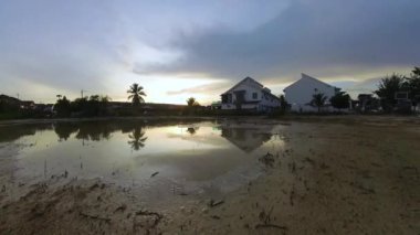 Boş arazinin yakınındaki yerleşim yerindeki altın saat sahnesinin hızlandırılmış görüntüleri..  