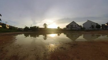 Boş arazinin yakınındaki yerleşim yerindeki altın saat sahnesinin hızlandırılmış görüntüleri..  