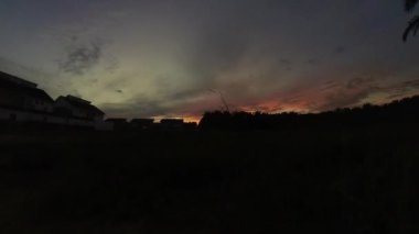 Boş arazinin yakınındaki yerleşim yerindeki altın saat sahnesinin hızlandırılmış görüntüleri..  