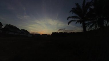 Boş arazinin yakınındaki yerleşim yerindeki altın saat sahnesinin hızlandırılmış görüntüleri..  