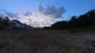 Boş arazinin yakınındaki yerleşim yerindeki altın saat sahnesinin hızlandırılmış görüntüleri..  