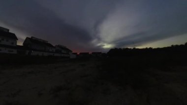 Boş arazinin yakınındaki yerleşim yerindeki altın saat sahnesinin hızlandırılmış görüntüleri..  