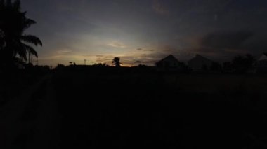 Boş arazinin yakınındaki yerleşim yerindeki altın saat sahnesinin hızlandırılmış görüntüleri..  