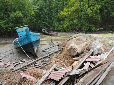 wooden dingy docked around the vicinity of the dried or low tide river outside the charcoal factory shed. clipart