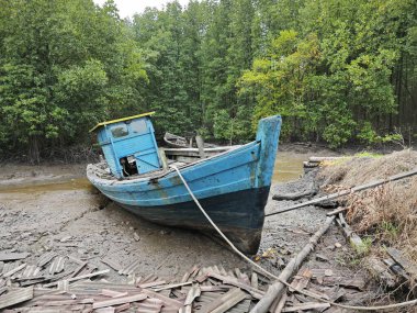 wooden dingy docked around the vicinity of the dried or low tide river outside the charcoal factory shed. clipart