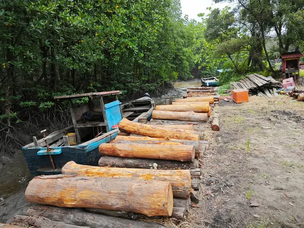 stock image wooden dingy docked around the vicinity of the dried or low tide river outside the charcoal factory shed.