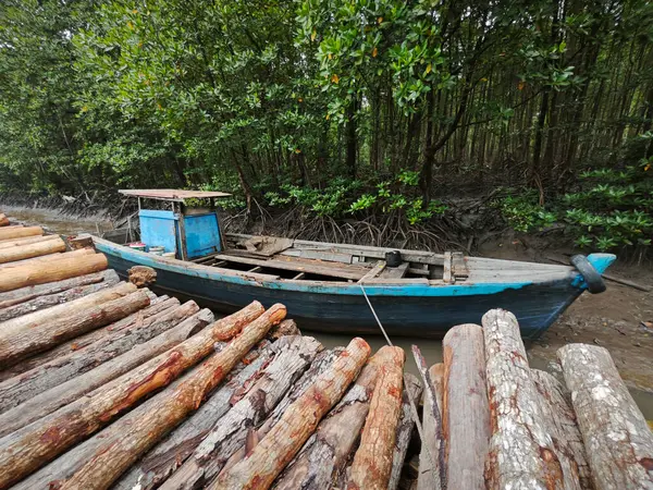 stock image wooden dingy docked around the vicinity of the dried or low tide river outside the charcoal factory shed.