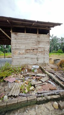 Tarım arazisindeki eski barakanın dışına çöpleri atmışlar..