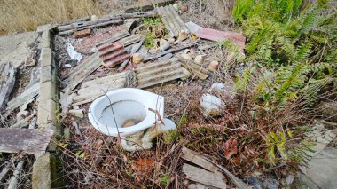 Tarım arazisindeki eski barakanın dışına çöpleri atmışlar..