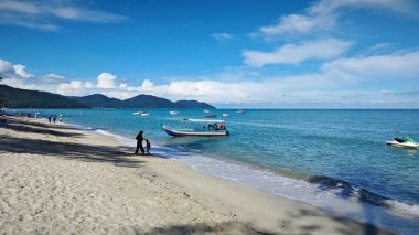 Penang, Malezya. 10 Kasım 2024: Batu Ferringhi sahilindeki kumlu sahil manzarası ve yerel eğlence etkinliği.