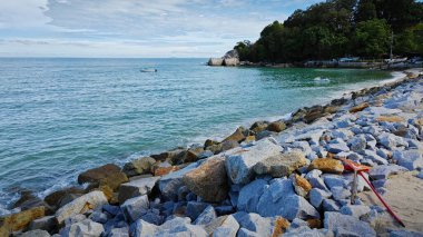 Beyaz kumlu sahil çevresindeki deniz manzarası.