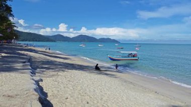 Penang, Malezya. 10 Kasım 2024: Yerel turistler Batu Ferringhi sahilindeki kumsal çevresindeki tatil ve deniz manzarası.  