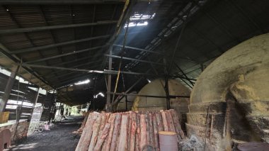 Perak,Malaysia. December 3, 2024: Dark environment scene inside the charcoal manufacturing industry factory production at Kelebung Charcoal Factory  clipart