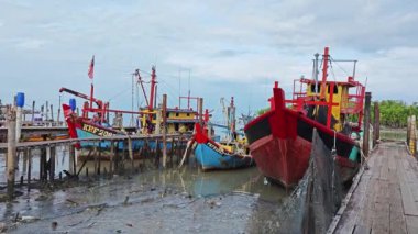 Perak, Malezya. 3 Aralık 2024: Pantai Remis Village Liman Güvertesi 'ndeki balıkçılık gezisinden döndükten sonra beton iskeleye yanaşan balıkçı teknelerinin görüntüsü. 