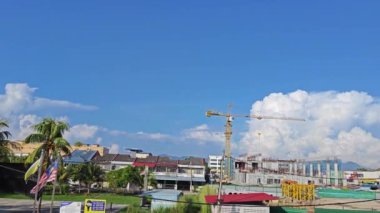 Perak, Malezya. 01 Aralık 2024: Güzel mavi bulutlu gökyüzü ve önplanında inşaat vinci olan Looking Good Yoğun Caddesi, Kg Koh. 
