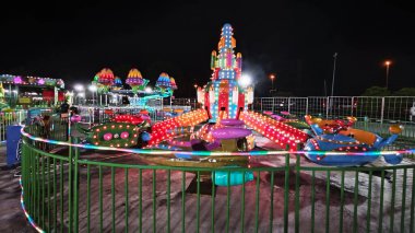 Perak, Malaysia. December 31, 2024: Variety of carousel amusement joyride night funfair on the open space around Aeon Mall vicinity, Sri Manjung.  clipart