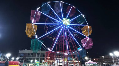 Perak, Malaysia. December 31, 2024: Variety of carousel amusement joyride night funfair on the open space around Aeon Mall vicinity, Sri Manjung. clipart