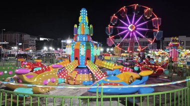 Perak, Malaysia. December 31, 2024: Variety of carousel amusement joyride night funfair on the open space around Aeon Mall vicinity, Sri Manjung. clipart