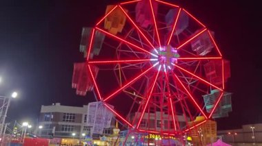 Perak, Malezya. 31 Aralık 2024: Aeon Mall civarındaki açık alanda atlıkarınca eğlencesi lunaparkında renkli bir gece sahnesi, Sri Manjung.