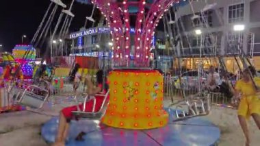 Perak, Malezya. 31 Aralık 2024: Aeon Mall civarındaki açık alanda atlıkarınca eğlencesi lunaparkında renkli bir gece sahnesi, Sri Manjung.