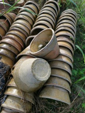 Çayır zemininde istenmeyen lateks seramik kap yığını.