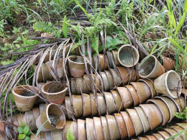 Çayır zemininde istenmeyen lateks seramik kap yığını.